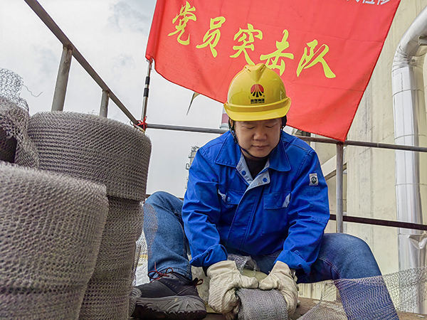 5月10日中午，在動力車間三期工藝除氧器平臺上，黨員突擊隊隊長李鑫正在纏繞新填料.jpg