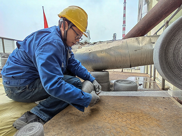 5月10日中午，在動力車間三期工藝除氧器平臺上，黨員突擊隊隊員劉瑞斌正在纏繞新填料.jpg