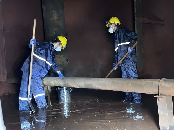 將熱水槽底部污水鏟倒廢桶中，用廢桶搬運出去.jpg